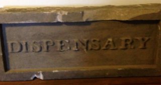 initial flagstone above dispensary door (writer's photograph)